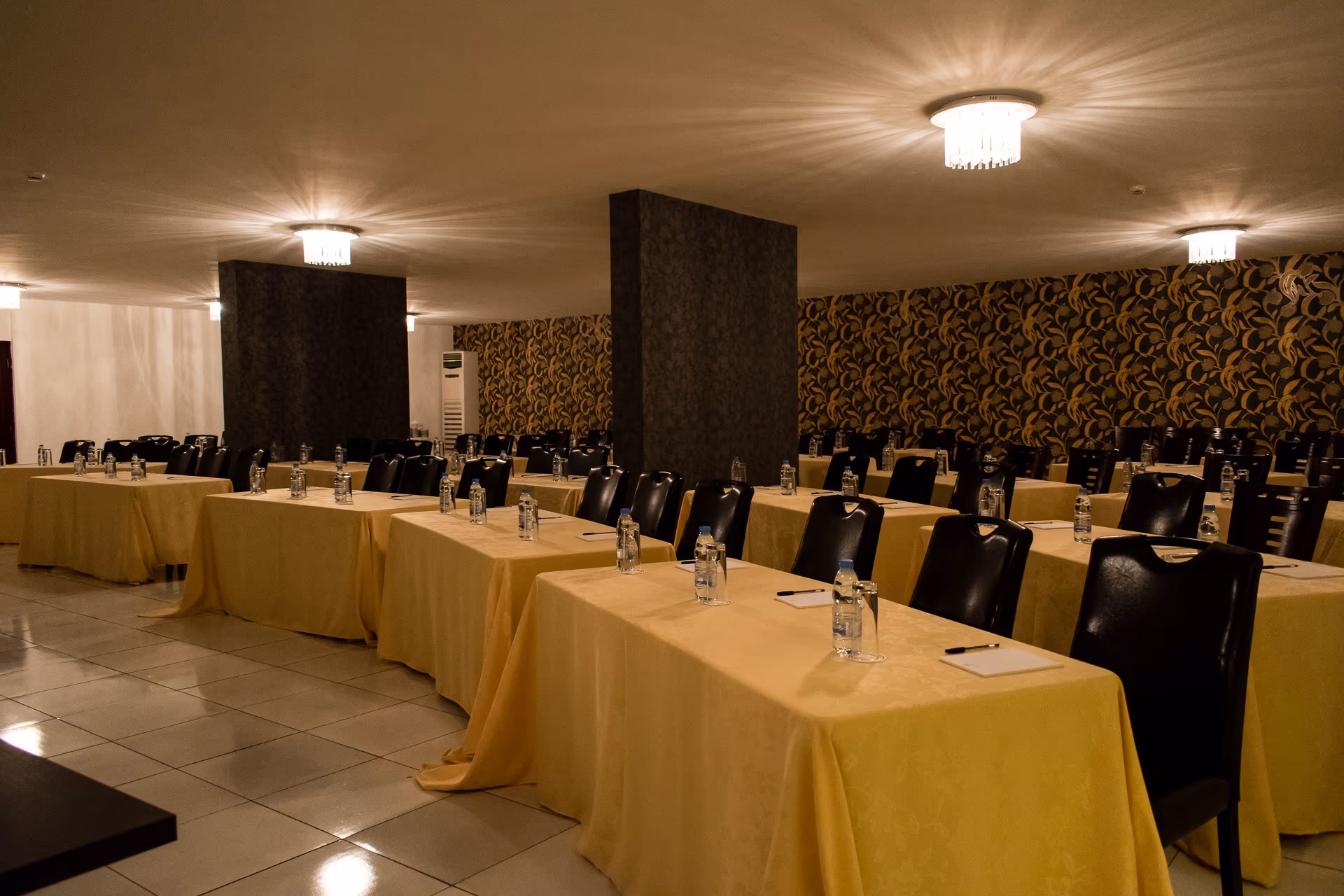 A function room laid out in rows of long tables facing the front, set for a seminar