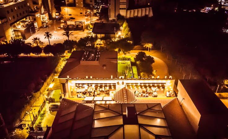The hotel and the surrounding streets seen from the air at night, lit up