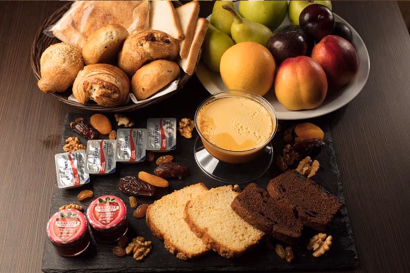 A breakfast spread of breads, pastries, fruit and preserves